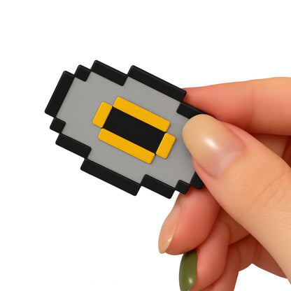 Hand holding a small rectangular object with black, gray, and yellow colors on a white background